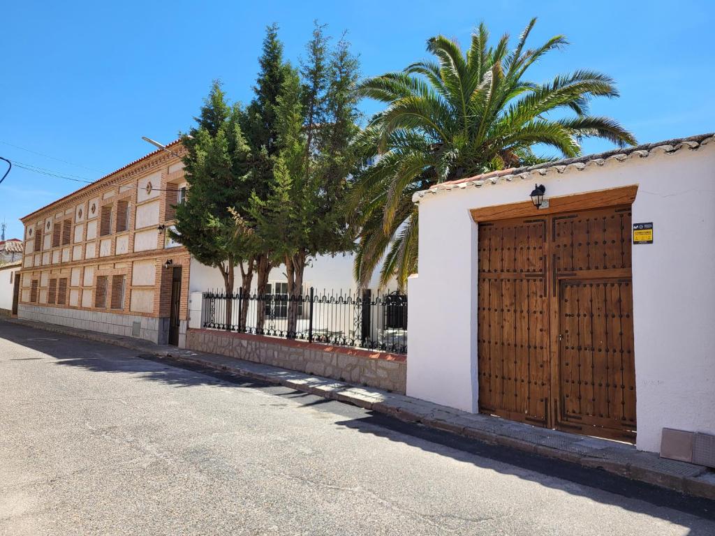 a building with a wooden door on the side of a street at Hostal la calma de Mascaraque in Mascaraque