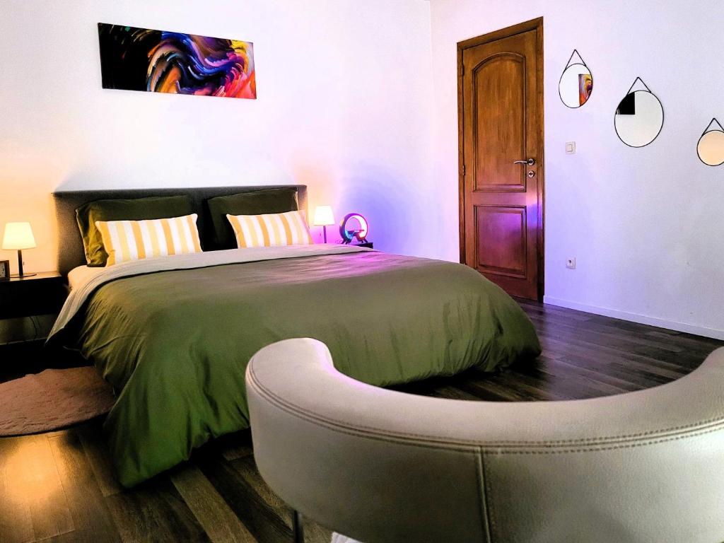 a bedroom with a large bed with a ottoman at Chez Toi Ailleurs - Dinant in Dinant