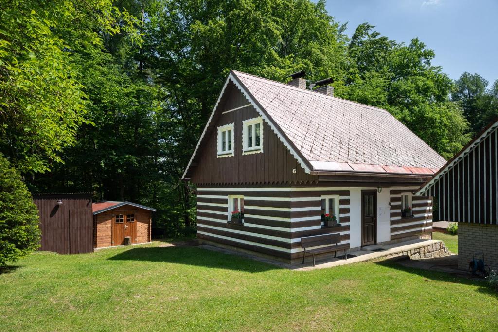 a small house with a gambrel roof on a yard at Chaloupka u Borovků in Vyskeř