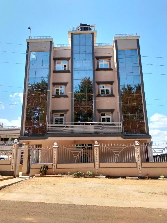 ein Gebäude mit verspiegelten Fenstern und einem Zaun in der Unterkunft Miriito's Hotel in Kisii