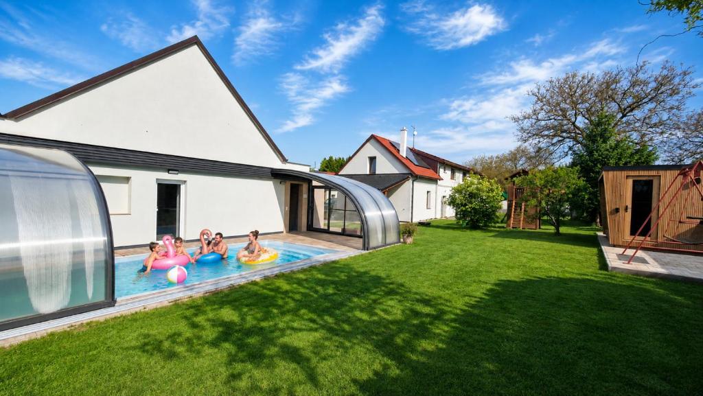 a family playing in the swimming pool of a house at Podbrdská chalupa in Nechanice