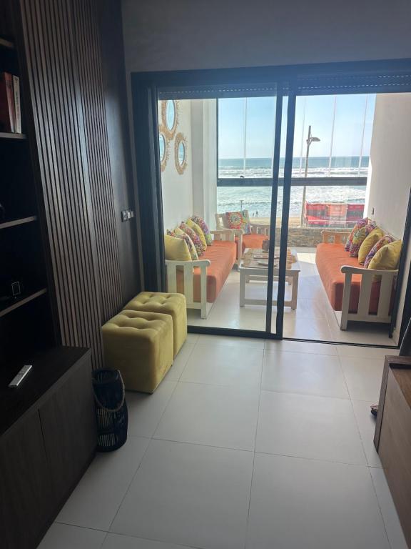 a living room with couches and a view of the ocean at résidence Copacabana mehdia in Kenitra