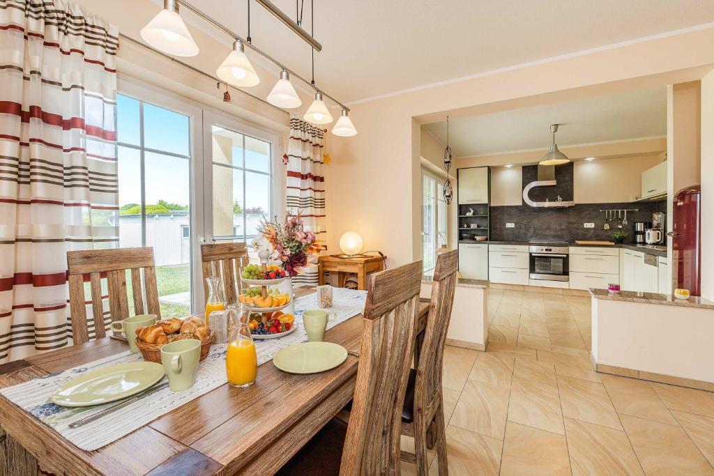 a kitchen and dining room with a wooden table and chairs at Ferienwohnung Auszeit am Meer in Koserow
