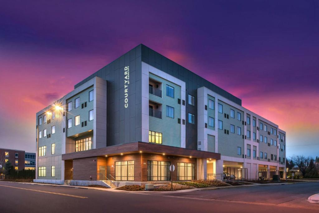 a rendering of a hotel building at dusk at Courtyard by Marriott Eugene Downtown in Eugene