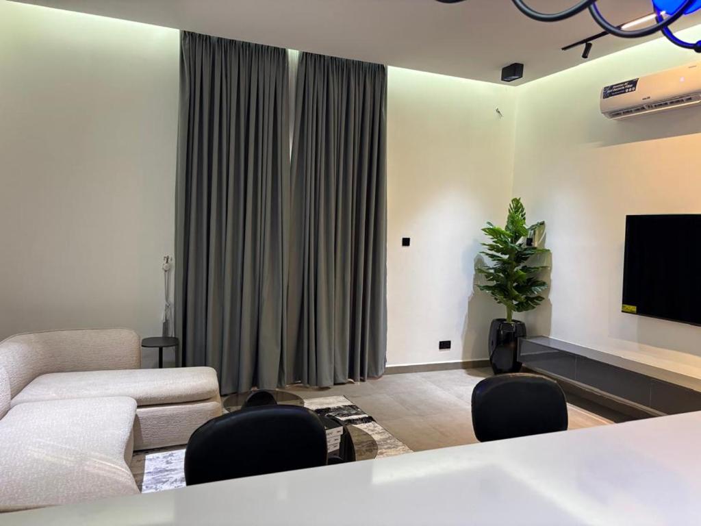 a living room with a couch and a flat screen tv at Reign Residence in Port Harcourt