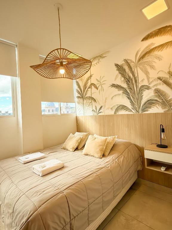 a bedroom with a large bed with a chandelier at Comodo dpto para 2 en pleno centro de Salta - Bonavista Rentals in Salta