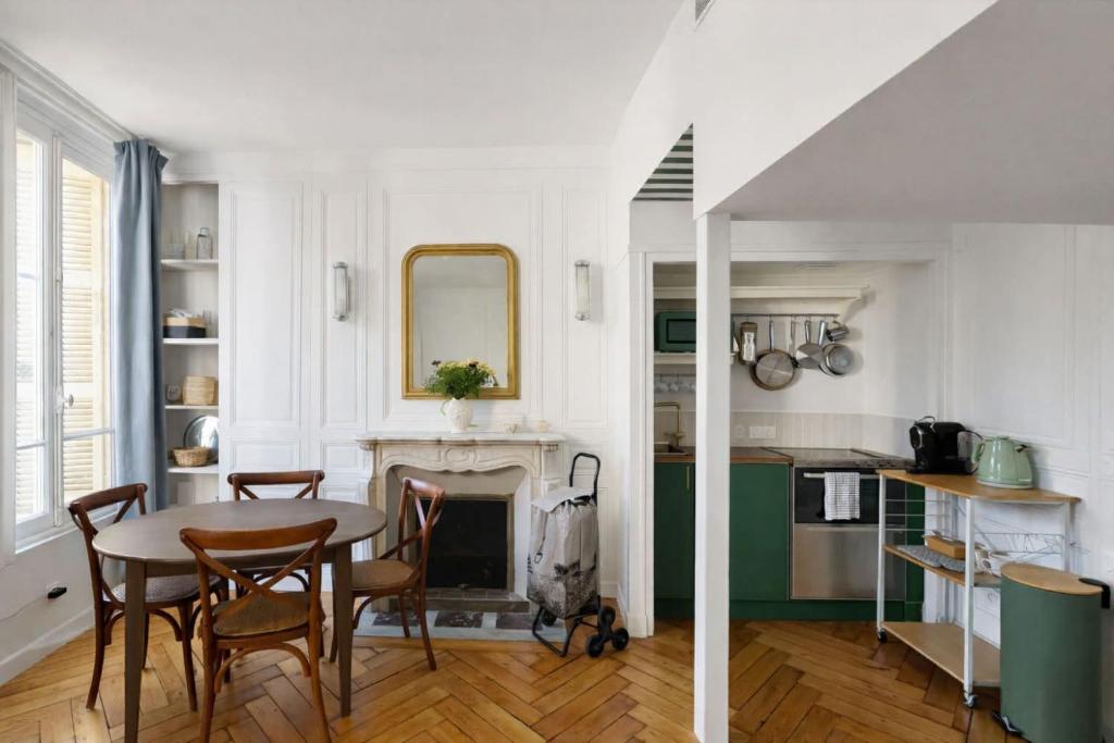 a kitchen with a table and chairs and a fireplace at Peaceful haven in Honfleur