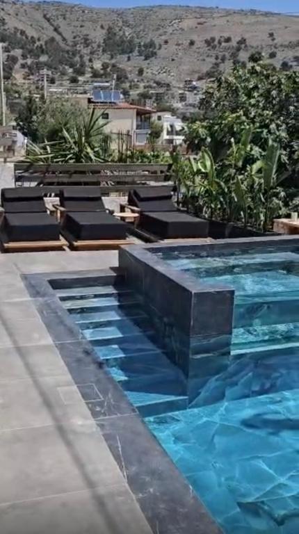 a swimming pool with blue water in a resort at Apartments Sadiku with swimming pool & jacuzzi in Sarandë