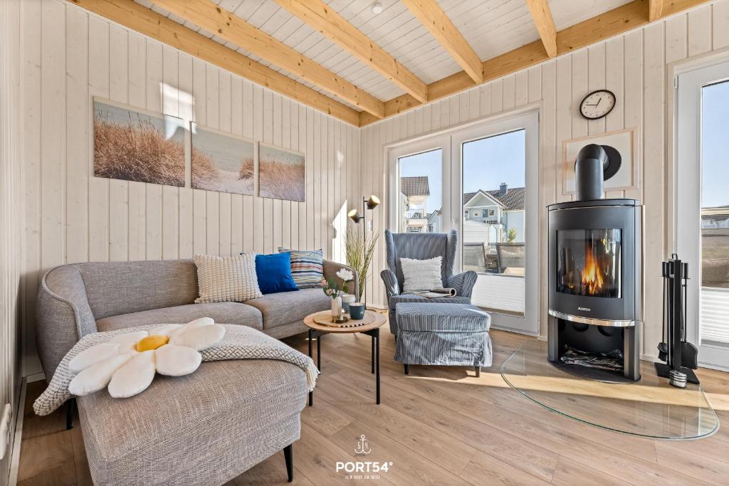 a living room with a couch and a fireplace at Ferienhaus Südheide Olpenitz in Olpenitz