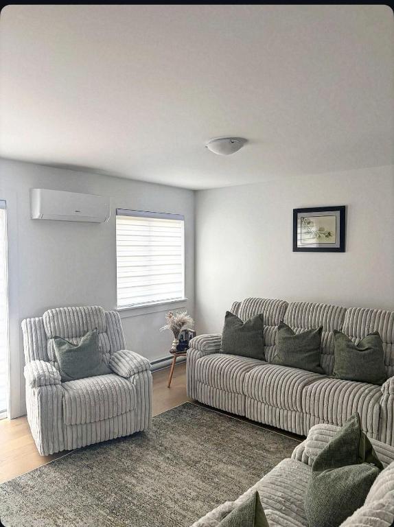 a living room with a couch and a chair at La perle de Dieppe in Dieppe