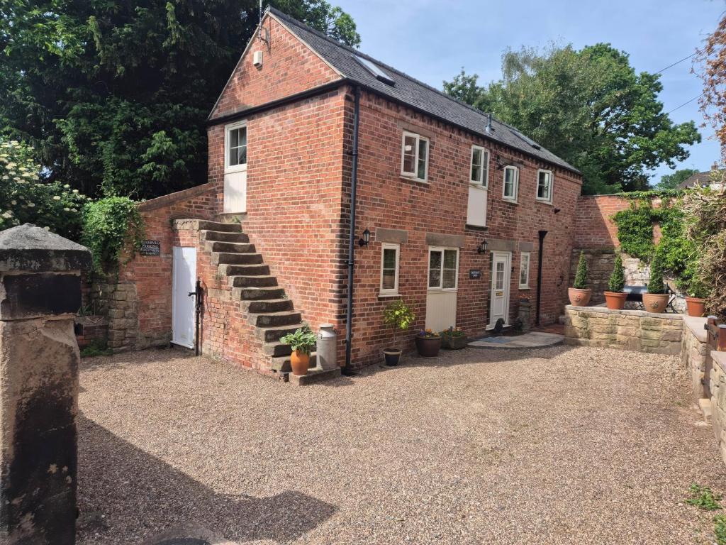 an external view of a brick building with a garage at Chestnuts Barn in Belper