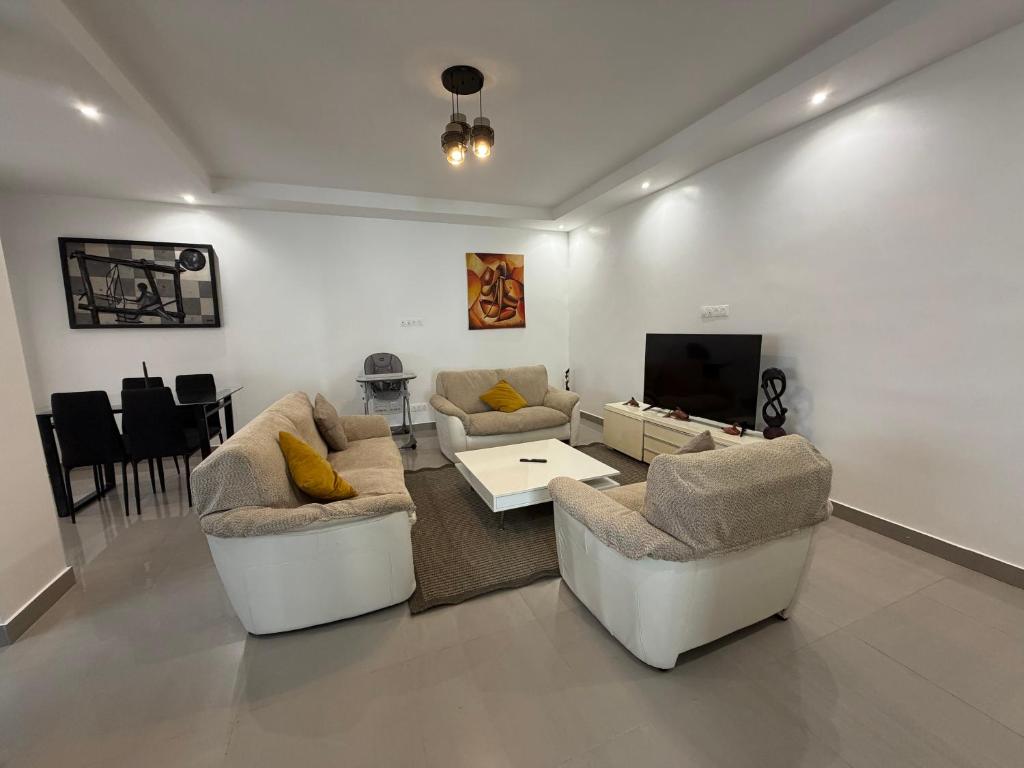 a living room with two couches and a tv at Le Welcome Almadies in Ngor