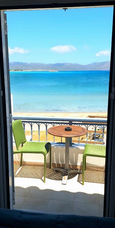 a balcony with a table and chairs and the ocean at Estella Studios in Elafonisos