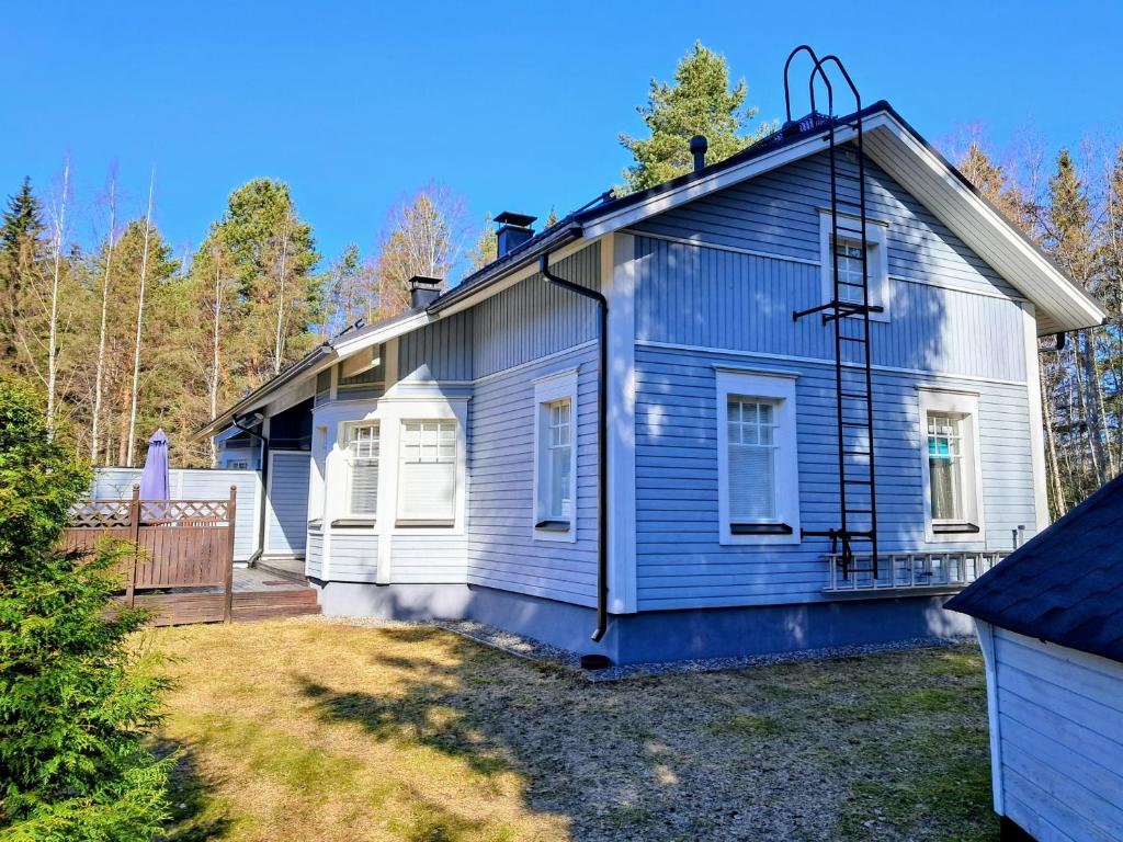 a blue and white house with a yard at Kasukkatie 2B in Tahkovuori