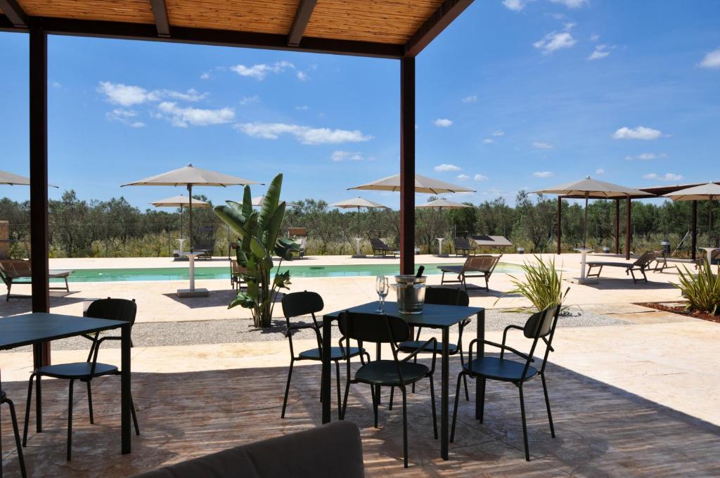 a patio with tables and chairs and a pool at Dimora Thalèa - Retreat & Rooms in Nardò