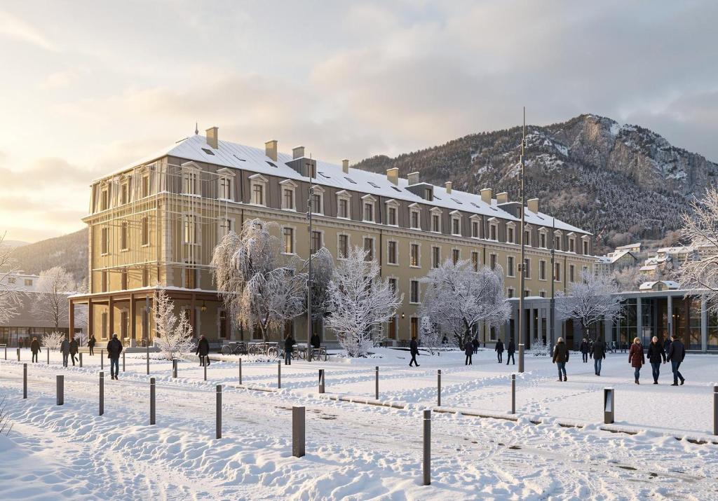 a building in the snow with people walking around it at DAFFY Hôtel in Briançon