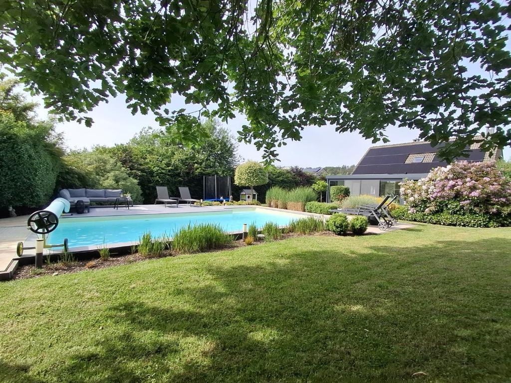 a swimming pool in the backyard of a house at LE CLOS DU MONTYS in Louveigné