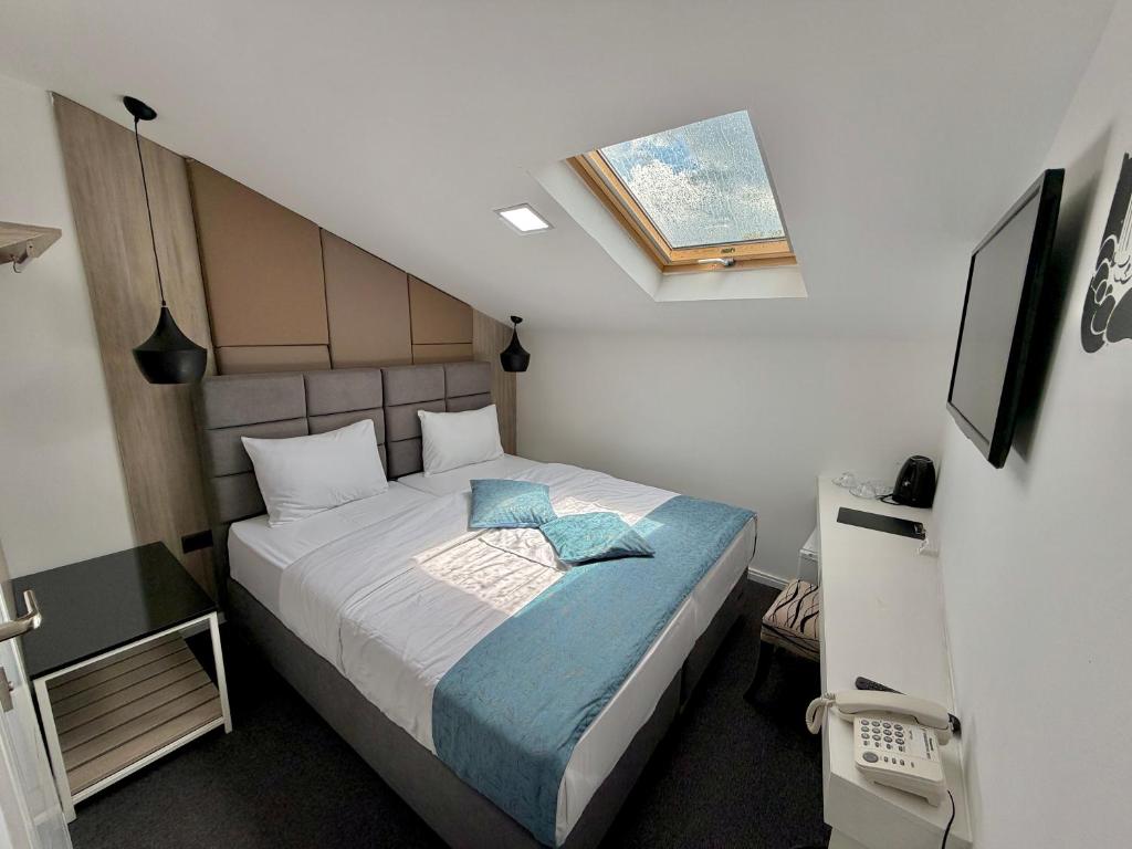 a small bedroom with a bed with a blue blanket at HOTEL PERLA - Free Parking in Sarajevo