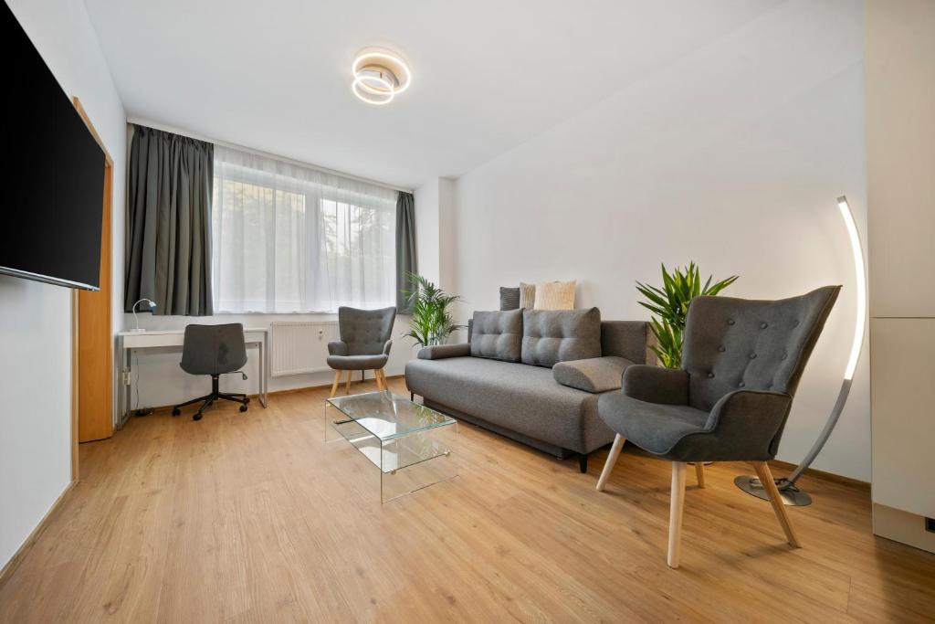 a living room with a couch and two chairs at Apartment Absolon in Komín
