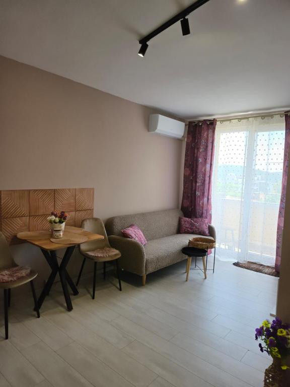 a living room with a couch and a table at Апартамент Туида 2 in Sliven