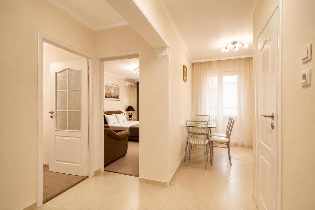 a living room with a table and a bedroom at Apartment Deluxe on Moscow Avenue in Chişinău