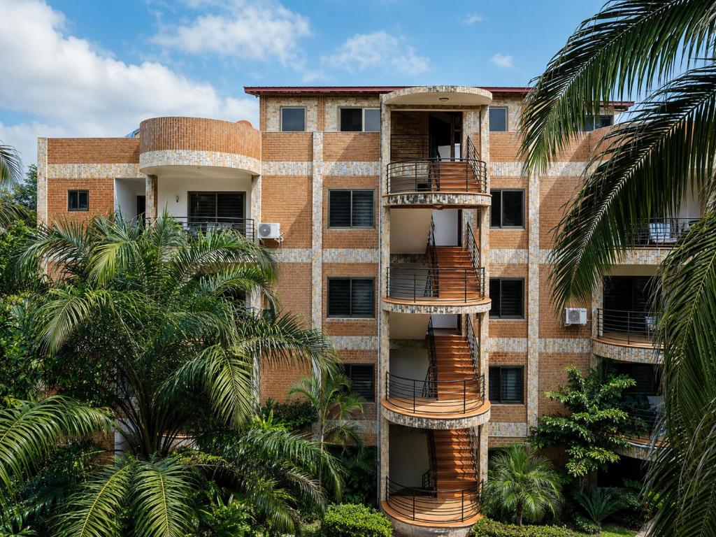 an apartment building with palm trees in front of it at Luxor Gardens Residences in Accra