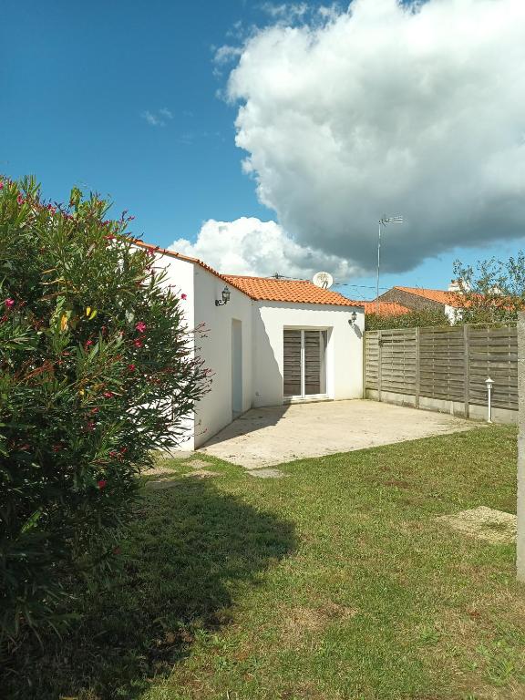 a white house with a fence in a yard at L'Estran qu'Île - Proche plages in LʼÎle-dʼOlonne