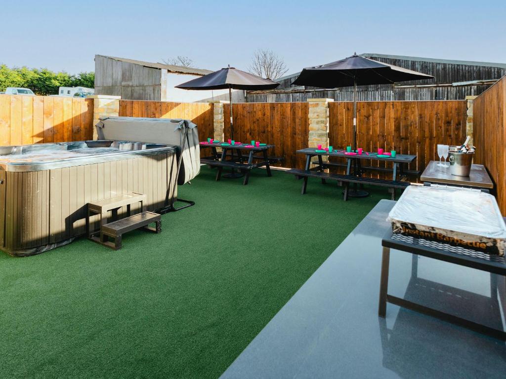 a patio with tables and chairs and a fence at St Hildas Rest in Hinderwell