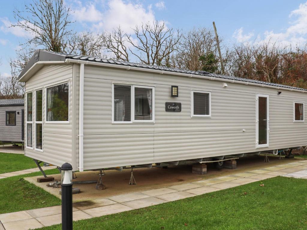 a white tiny house on display in a yard at Birch 3 - Ukc8216 in Pendine