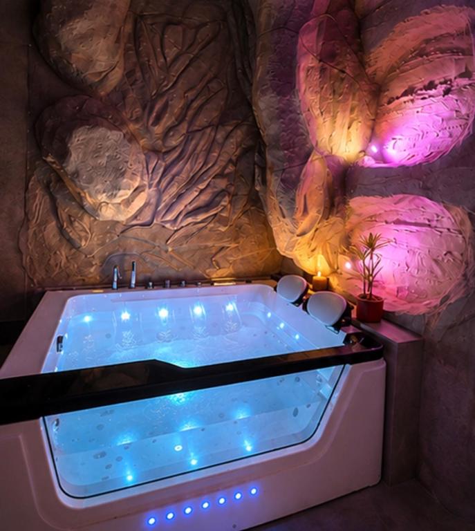 a bath tub in a room with a rock wall at Sanctuaire bien-être in Sélestat