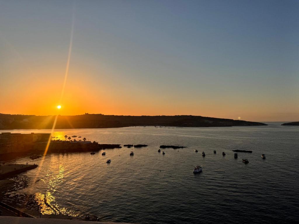 a group of people in the water at sunset at Brand new Oceanview Penthouse by MaBeLi in St. Paul's Bay