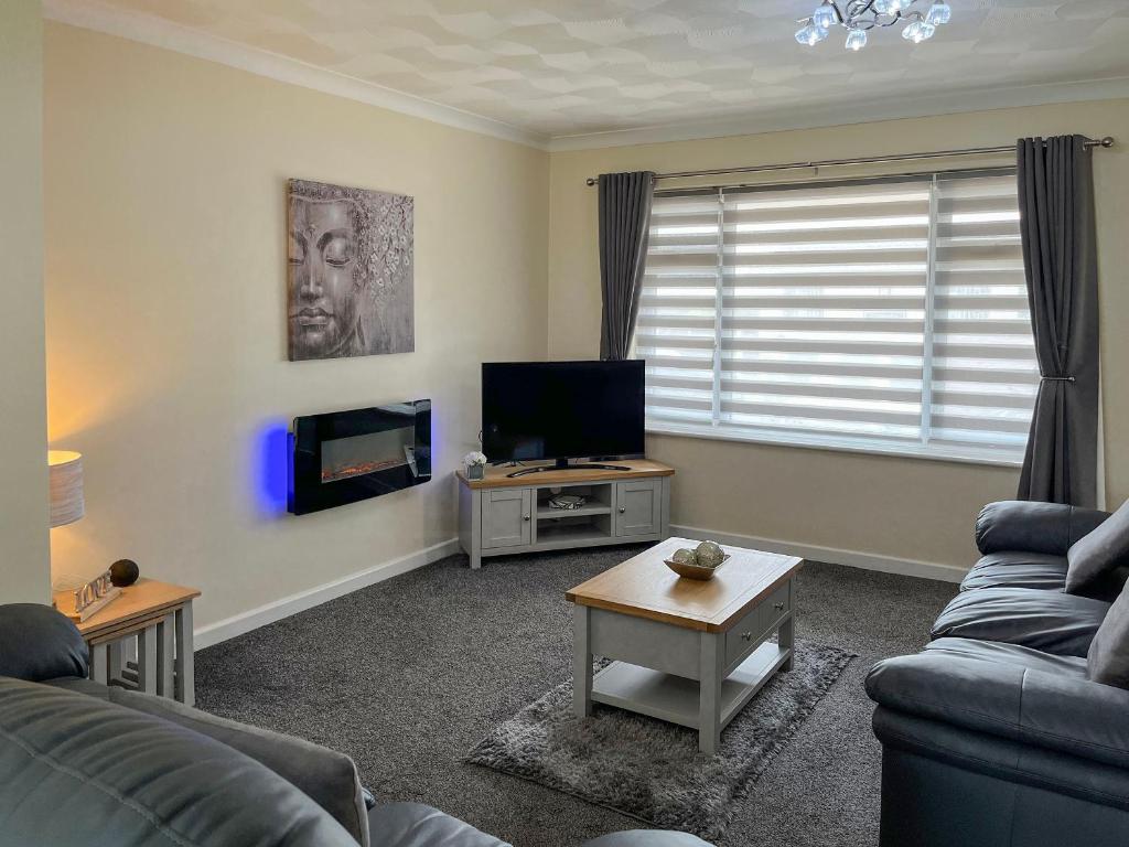 a living room with a couch and a tv at White Towers - Hw7625 in Llandwrog