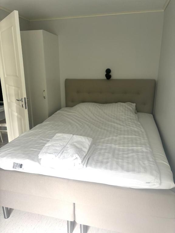 a white bed in a white room with a mattress at Björklunden in Sollefteå