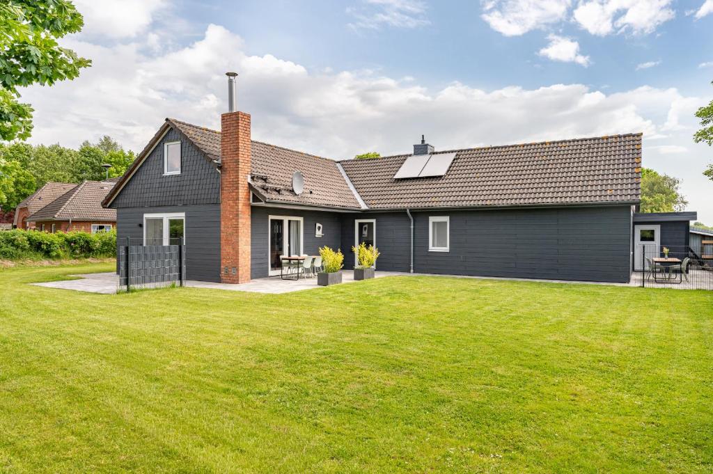 a house with a lawn in front of it at Cottage am Deich Whg Mareile in Uelvesbüll