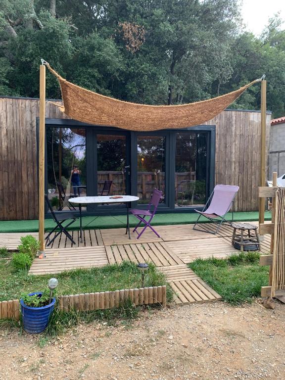 a patio with chairs and a table and a net at Le Chalet in Taillet