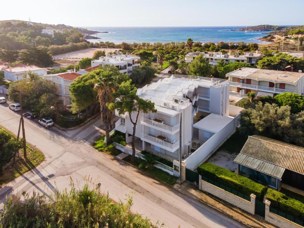an aerial view of a white building with the ocean in the background at PJ Properties Studio in Sounio steps away from the beach in Sounio