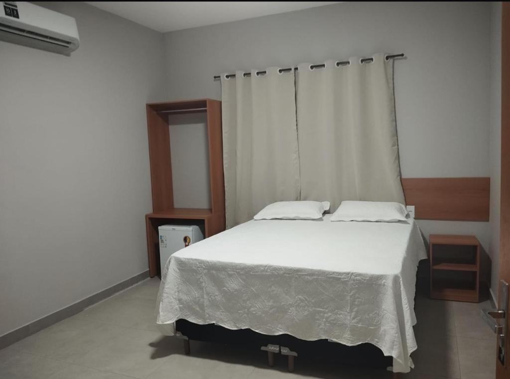 a bedroom with a large bed with white sheets at Hotel Paris in Balsas