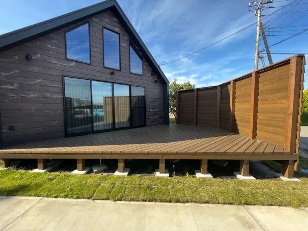 a house with a wooden deck on the side of it at Beringei house Kujukuri in Katakai