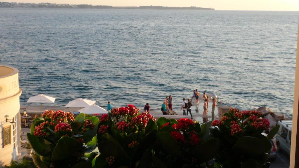 um grupo de pessoas na praia perto da água em Allure Apartments em Piran