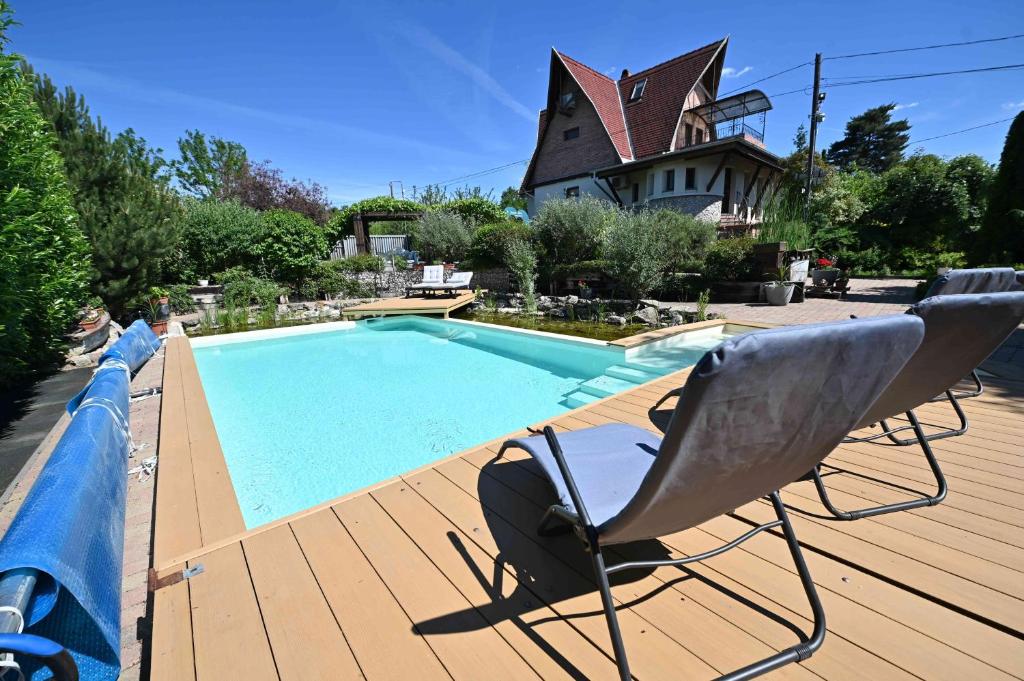 a chair sitting on a deck next to a swimming pool at Vintage Home Vendégház in Miskolctapolca