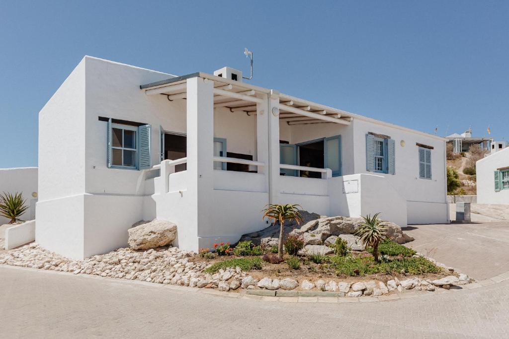 a white house with palm trees in front of it at Duifie in Paternoster