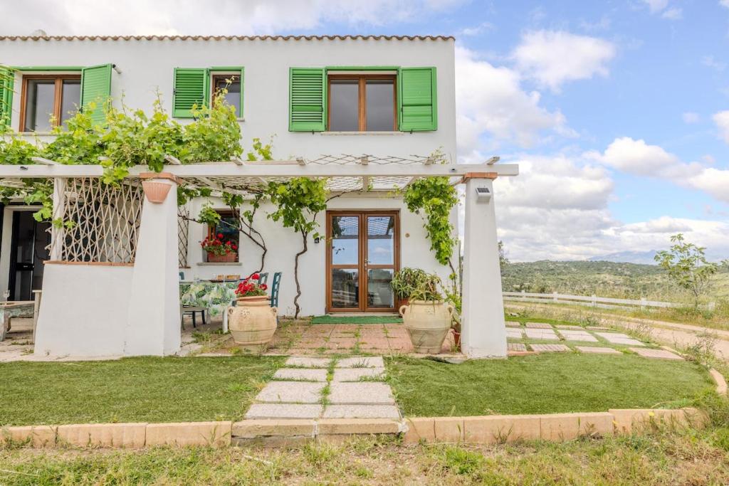 a white house with green shutters at Rai's Room 1 - Nature and Panoramic View in Stazione Olbia