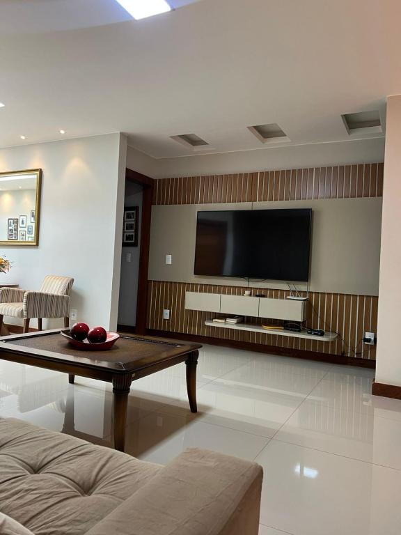 a living room with a flat screen tv on a wall at Apartamento amplo João VI in Muriaé
