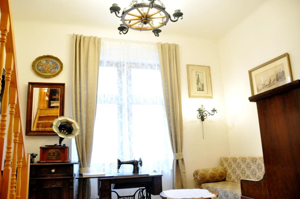 een woonkamer met een raam en een kroonluchter bij Traditional Slovak Apartment in Bratislava