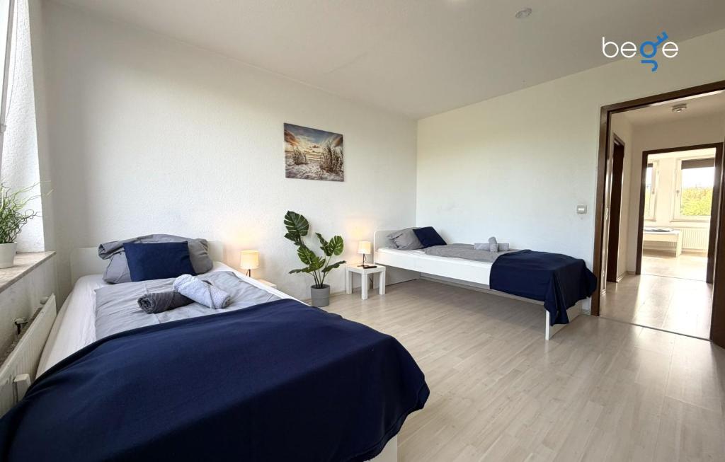 a bedroom with two beds with blue sheets at BEGE APARTMENTS HomeAway in Marl
