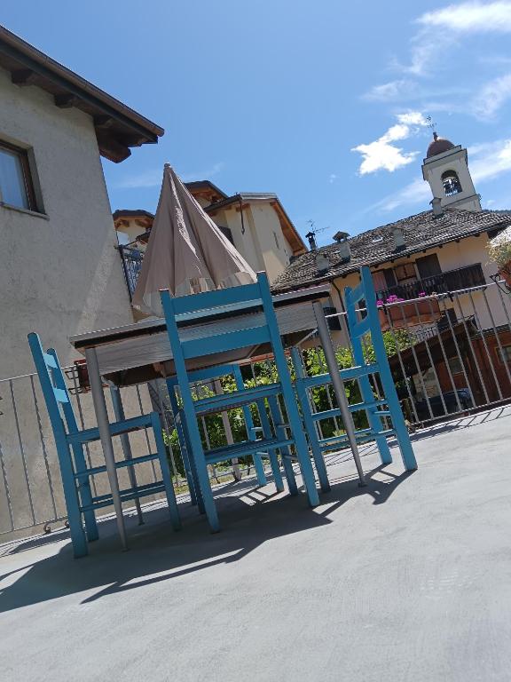 a pair of blue chairs in front of a building at Nonna Lidie in Aymavilles