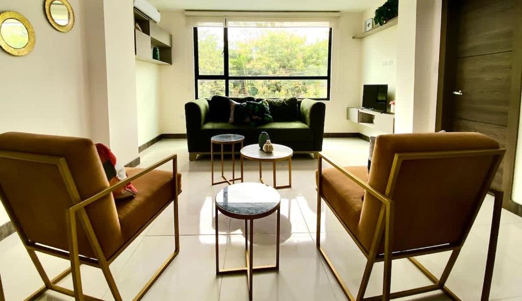 a living room with two chairs and a couch at Lovely 2BD City Condo with parking in Guayaquil