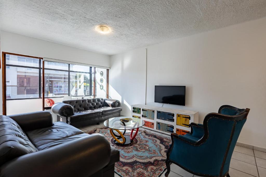 a living room with a couch and a tv at Safi Self-catering Suite 2 in Bunkers Hill