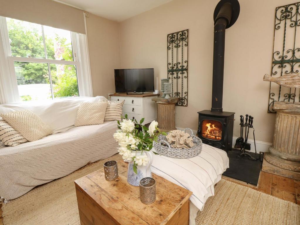 a living room with a couch and a fireplace at Fern Cottage in Bembridge