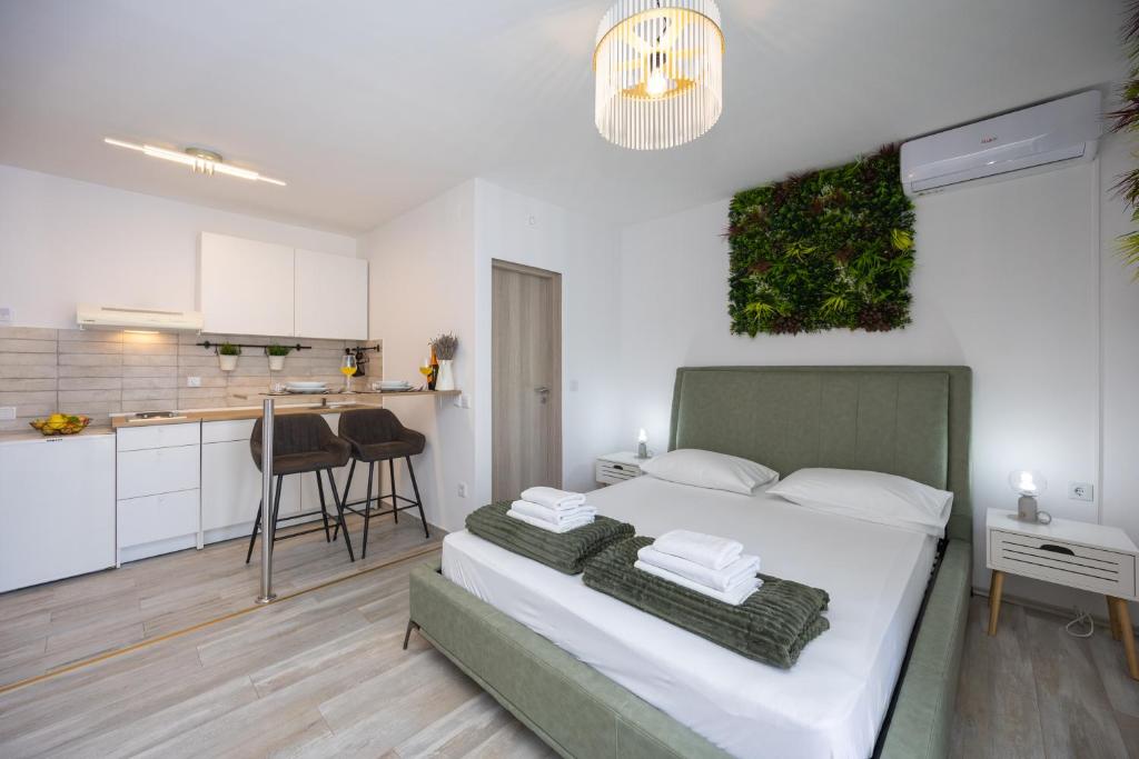 a bedroom with a large bed and a kitchen at Apartments Milas in Okrug Gornji